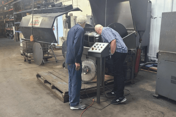 2 men looking at remanufactured compressor